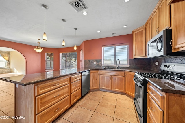 kitchen with decorative backsplash, appliances with stainless steel finishes, kitchen peninsula, and hanging light fixtures