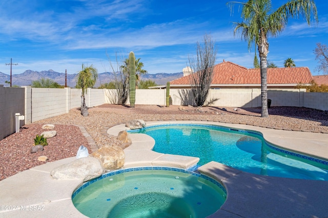 view of pool featuring an in ground hot tub and a mountain view