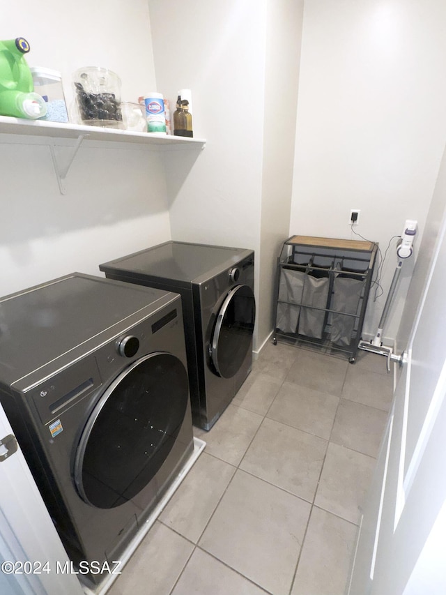 clothes washing area with light tile patterned flooring and washing machine and clothes dryer