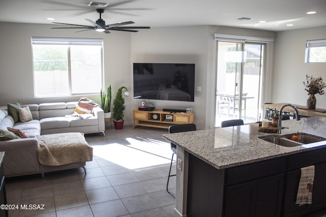 living room featuring tile patterned floors, ceiling fan, and sink