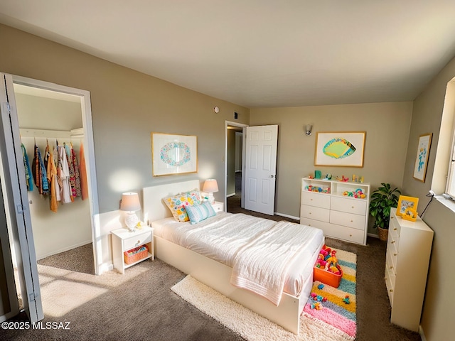 carpeted bedroom with a spacious closet and a closet