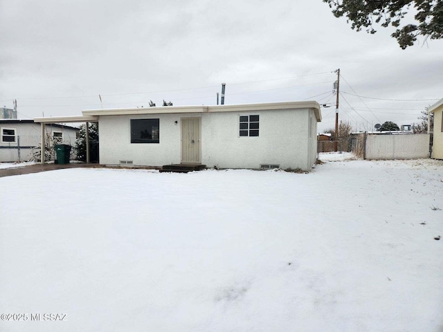 view of snow covered back of property