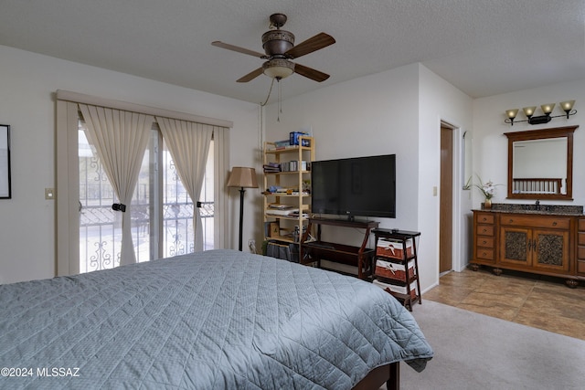 bedroom featuring ceiling fan, a textured ceiling, and light carpet