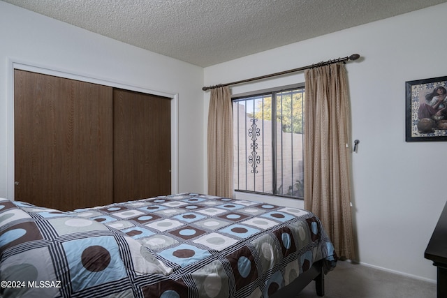 carpeted bedroom featuring a closet and a textured ceiling