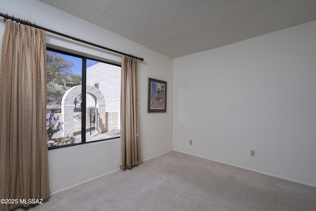 carpeted empty room featuring a textured ceiling