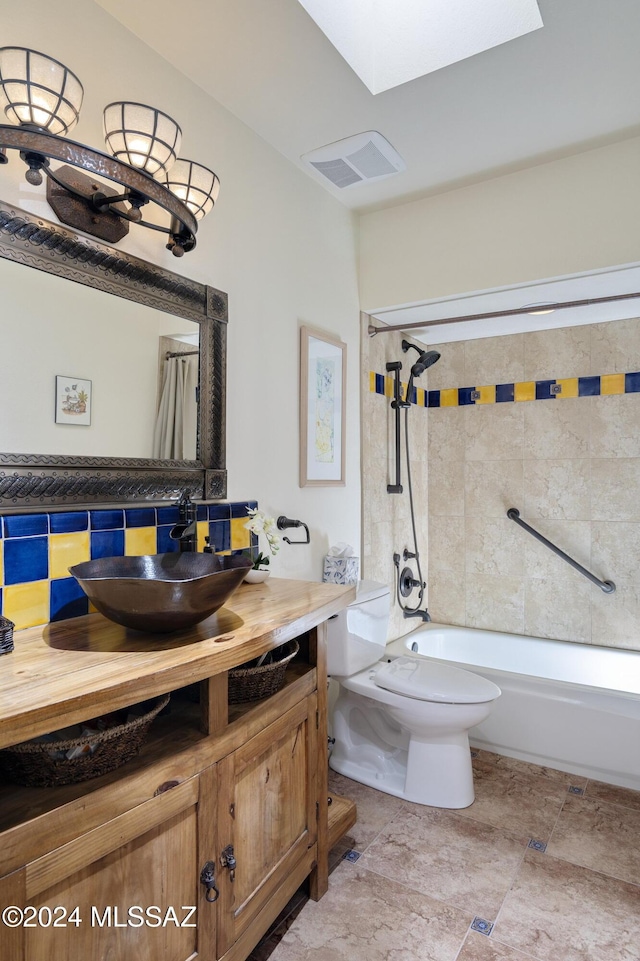 full bathroom featuring shower / bath combination with curtain, tasteful backsplash, a skylight, vanity, and toilet