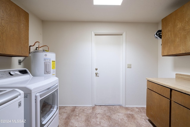 clothes washing area with cabinets, electric water heater, and washer and clothes dryer