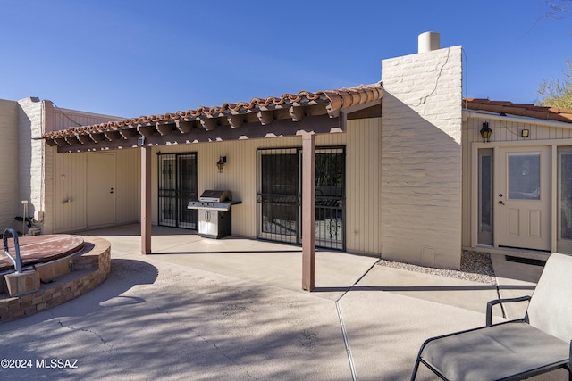 view of patio featuring a covered hot tub and grilling area