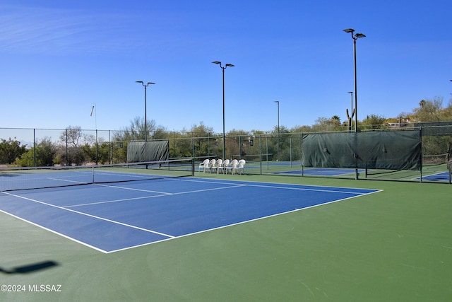 view of tennis court featuring fence