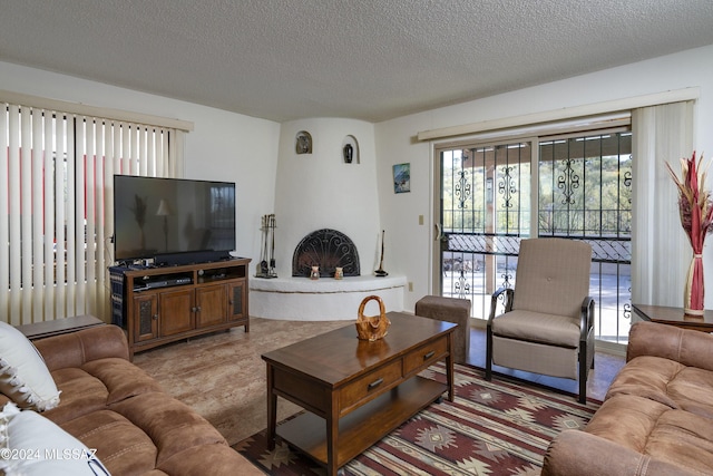 living room featuring a textured ceiling and a fireplace