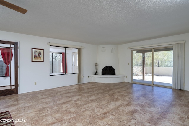 unfurnished living room featuring a large fireplace and a textured ceiling