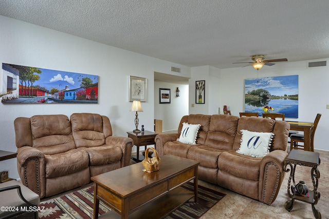 living room with carpet, ceiling fan, and a textured ceiling