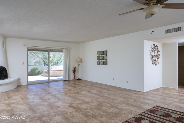 unfurnished living room with visible vents, ceiling fan, and a textured ceiling