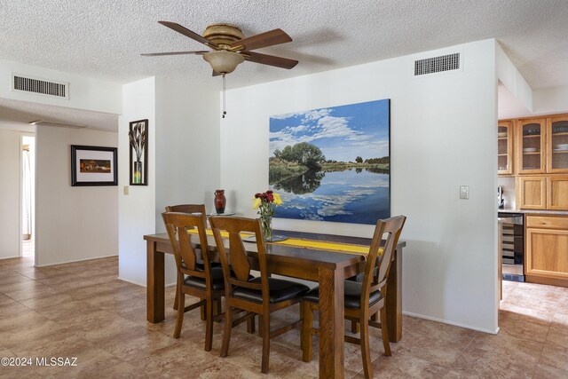 dining area featuring ceiling fan and beverage cooler