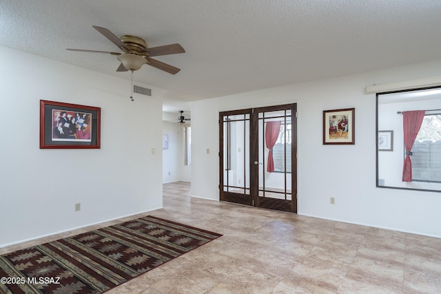 spare room featuring a textured ceiling, french doors, visible vents, and a ceiling fan