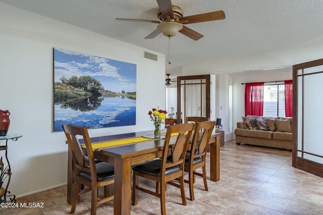 dining space with a textured ceiling and ceiling fan