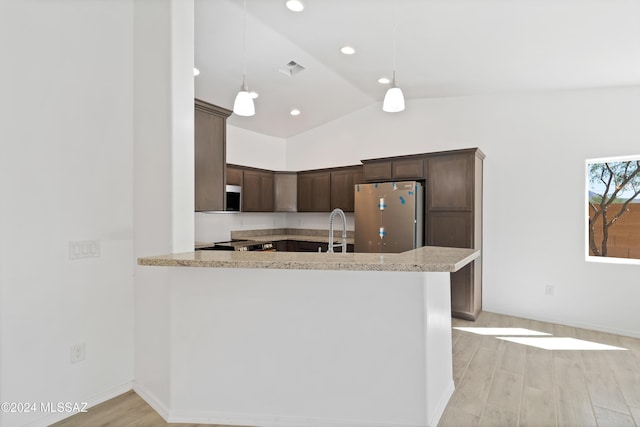 kitchen with kitchen peninsula, appliances with stainless steel finishes, decorative light fixtures, and light hardwood / wood-style floors