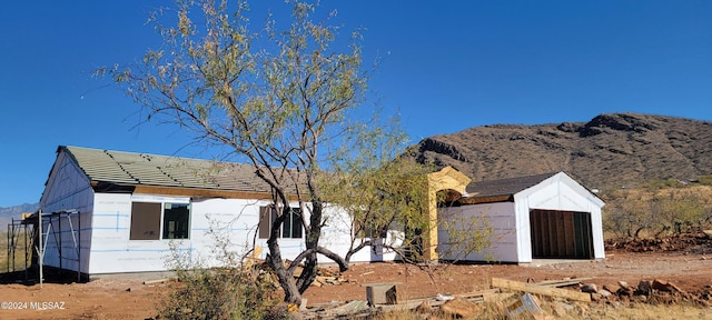 exterior space featuring a mountain view, a garage, and an outbuilding