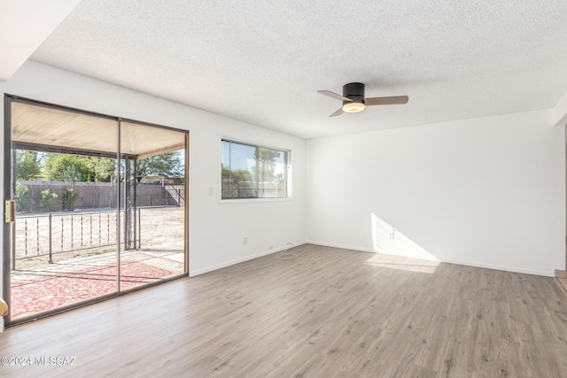 empty room with a textured ceiling, hardwood / wood-style flooring, and ceiling fan