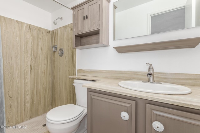 bathroom featuring vanity, toilet, and walk in shower