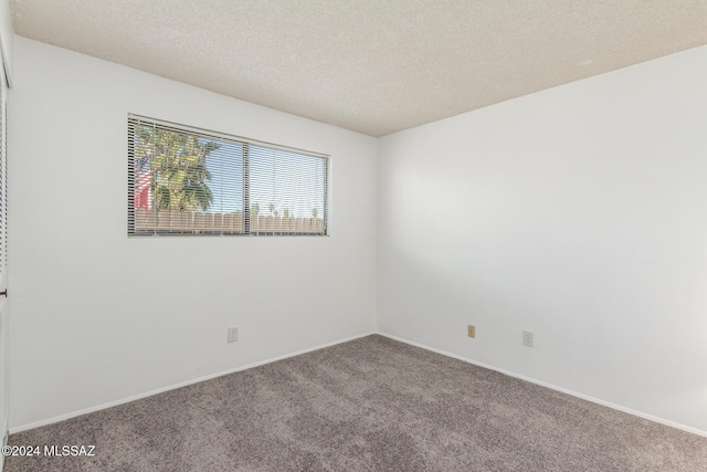 carpeted spare room with a textured ceiling