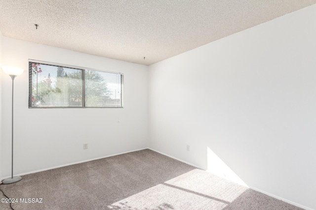 carpeted spare room featuring a textured ceiling