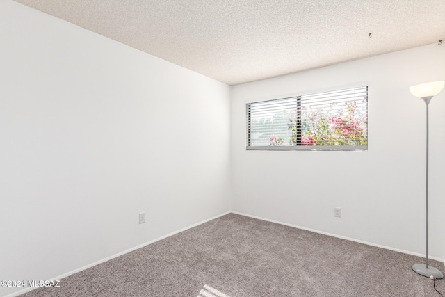 carpeted spare room with a textured ceiling