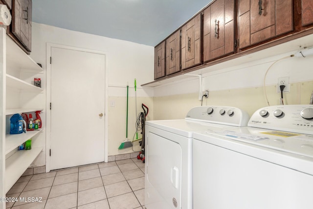 laundry area featuring cabinets, light tile patterned flooring, and washing machine and clothes dryer