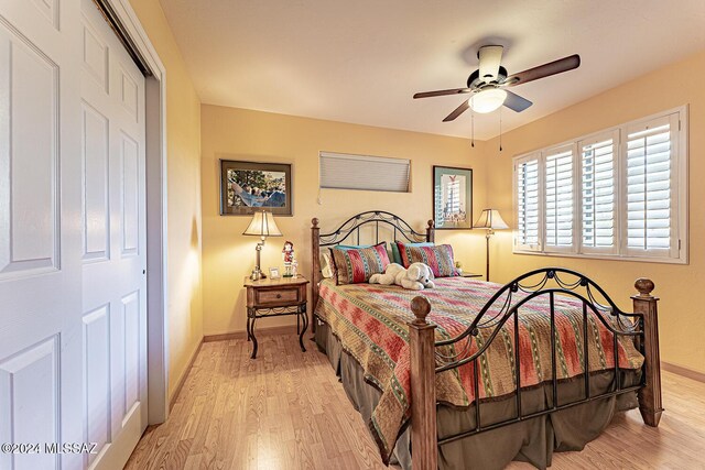 bedroom with ceiling fan, light hardwood / wood-style flooring, and a closet