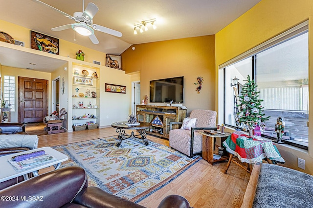 living room featuring ceiling fan, hardwood / wood-style floors, track lighting, and lofted ceiling