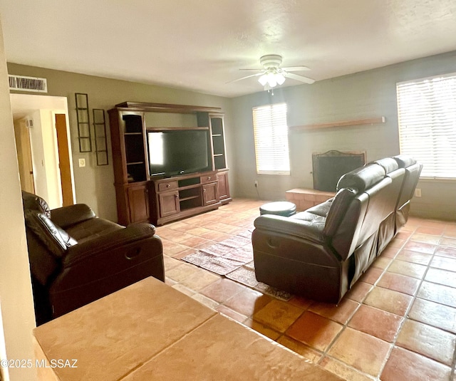 tiled living room with ceiling fan and a wealth of natural light