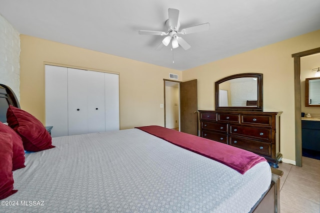 tiled bedroom with connected bathroom, a closet, and ceiling fan