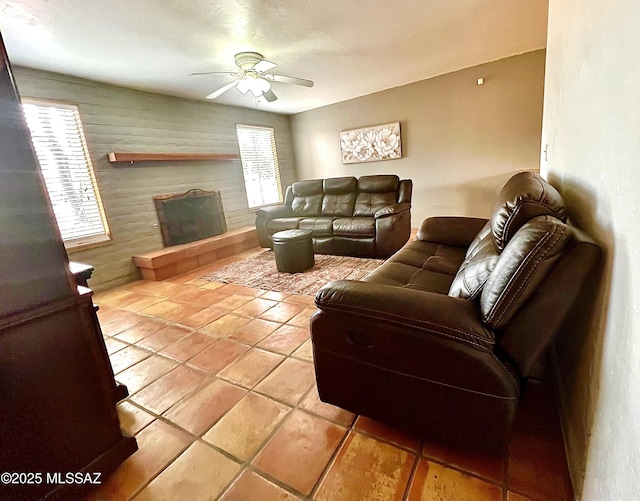 living room featuring a fireplace and ceiling fan