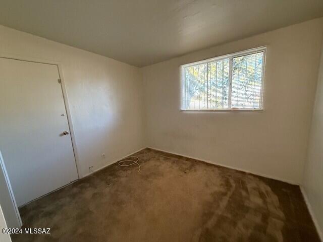 empty room featuring dark carpet