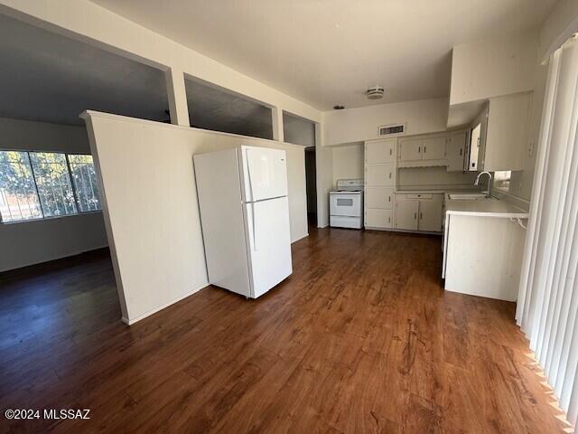 kitchen featuring dark hardwood / wood-style flooring, sink, stove, and white refrigerator