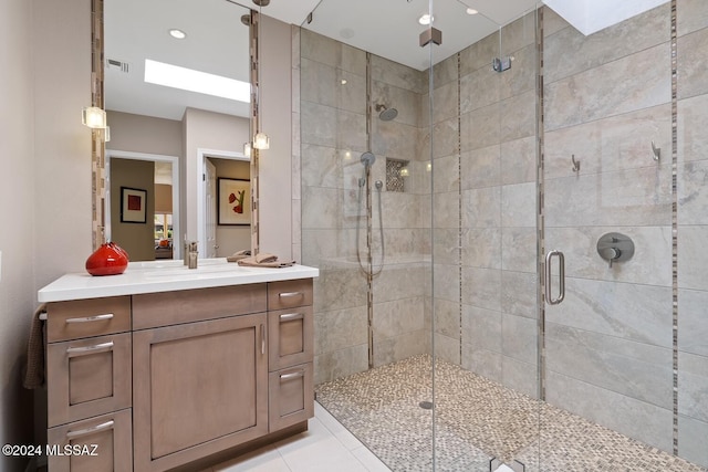 bathroom featuring tile patterned flooring, an enclosed shower, and vanity