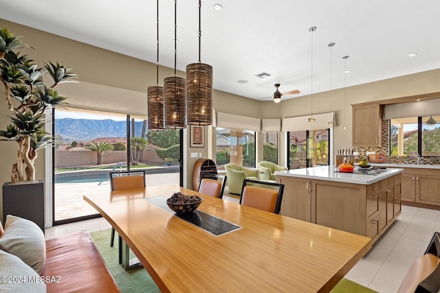 dining area featuring ceiling fan, light tile patterned floors, and a mountain view