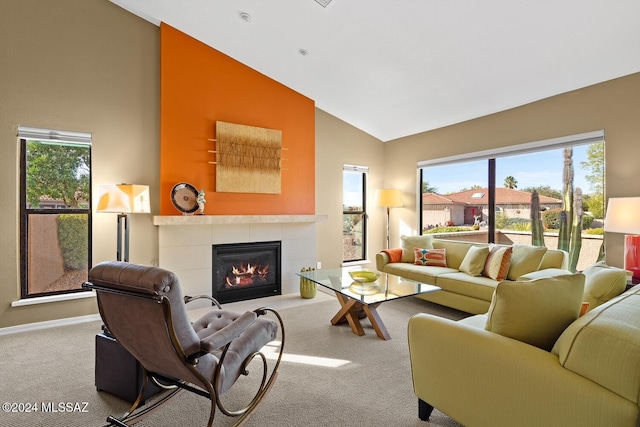 living room with a tiled fireplace, high vaulted ceiling, and light carpet