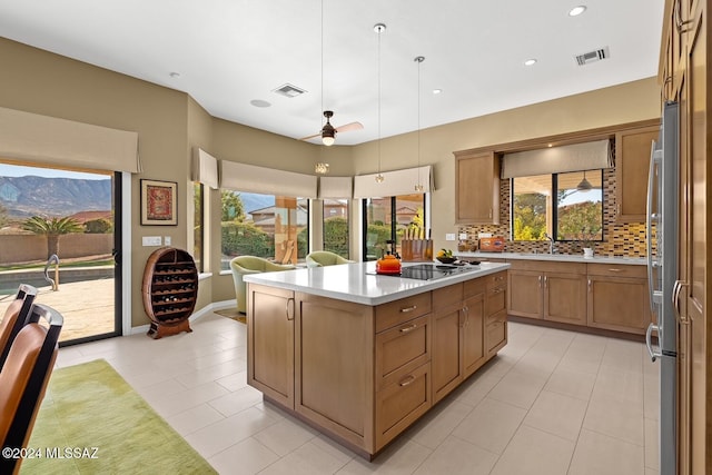 kitchen featuring a center island, hanging light fixtures, a mountain view, black electric stovetop, and ceiling fan