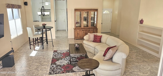 living room with light tile patterned floors and an inviting chandelier