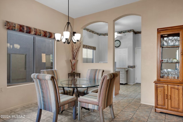 tiled dining room with a chandelier