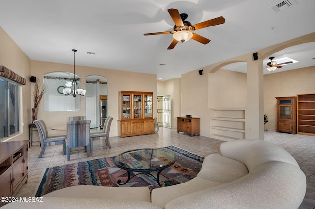 living room featuring ceiling fan with notable chandelier and light tile patterned floors