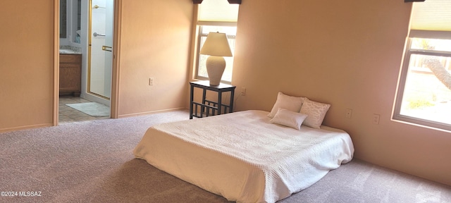 carpeted bedroom featuring connected bathroom