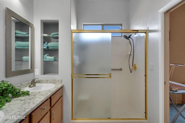 bathroom with vanity and a shower with shower door