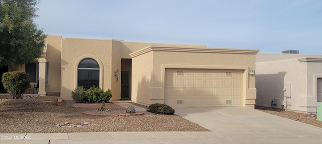 pueblo-style house featuring a garage