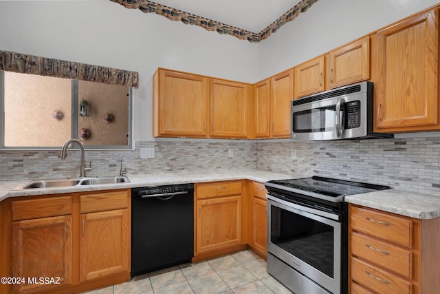 kitchen with tasteful backsplash, sink, light tile patterned floors, and appliances with stainless steel finishes