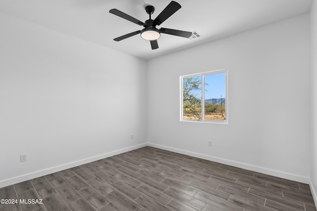 empty room featuring ceiling fan and dark wood-type flooring