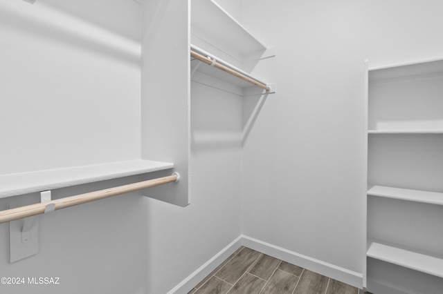 walk in closet with dark hardwood / wood-style flooring