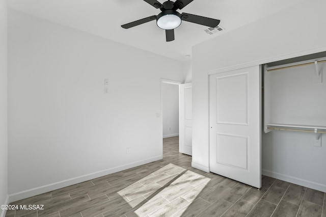 unfurnished bedroom with ceiling fan, a closet, and hardwood / wood-style floors