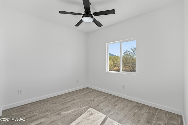 empty room with ceiling fan and light hardwood / wood-style flooring